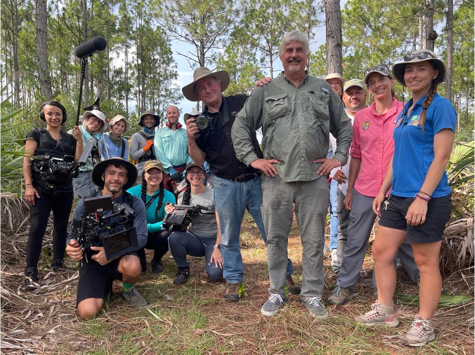 group of young people with camers, video equipment and sound equipment in the woods